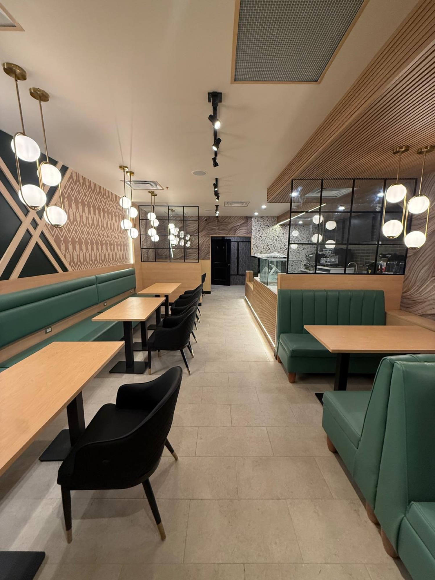 Contemporary café with green banquettes, wood millwork and glass partitions