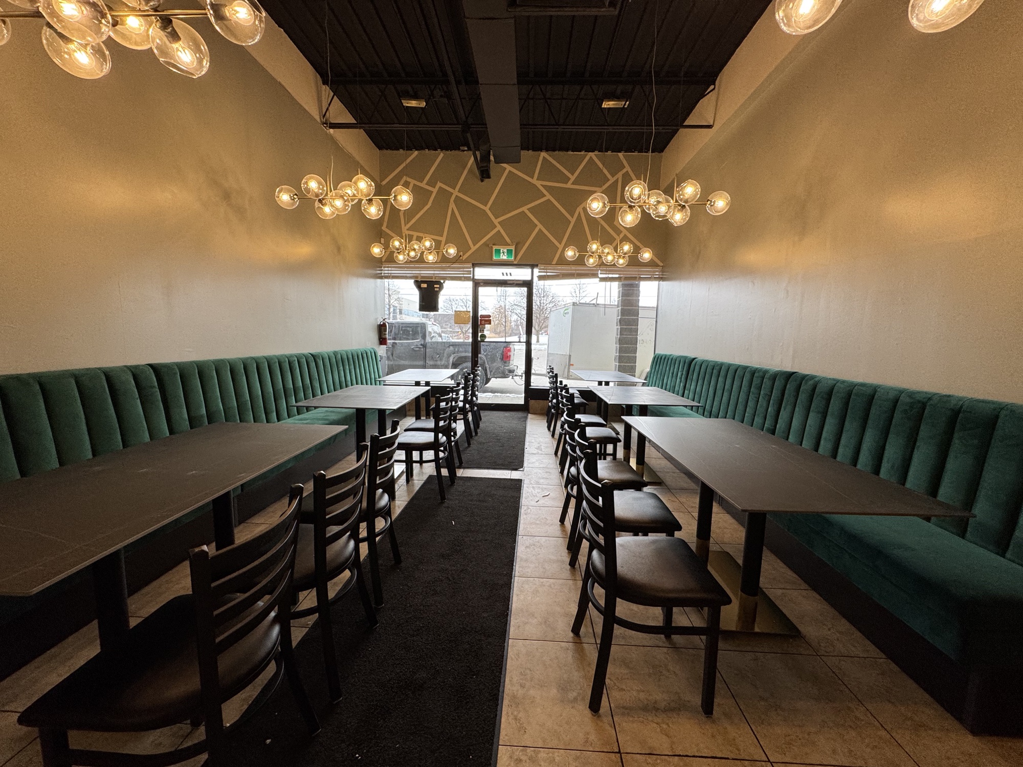 Green restaurant banquettes integrated with warm wood dividers