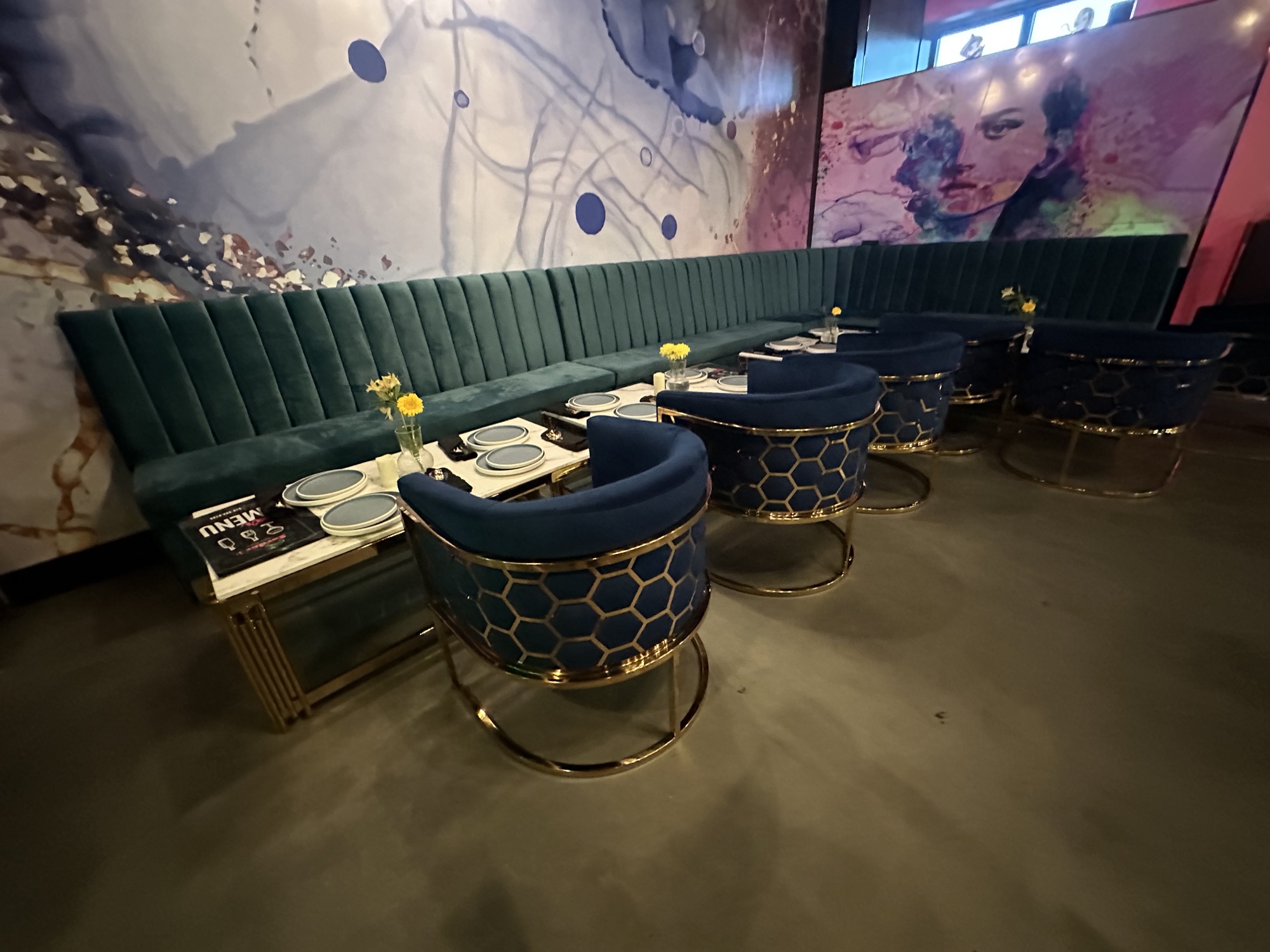 Restaurant lounge with sculptural green chairs and a large shared table